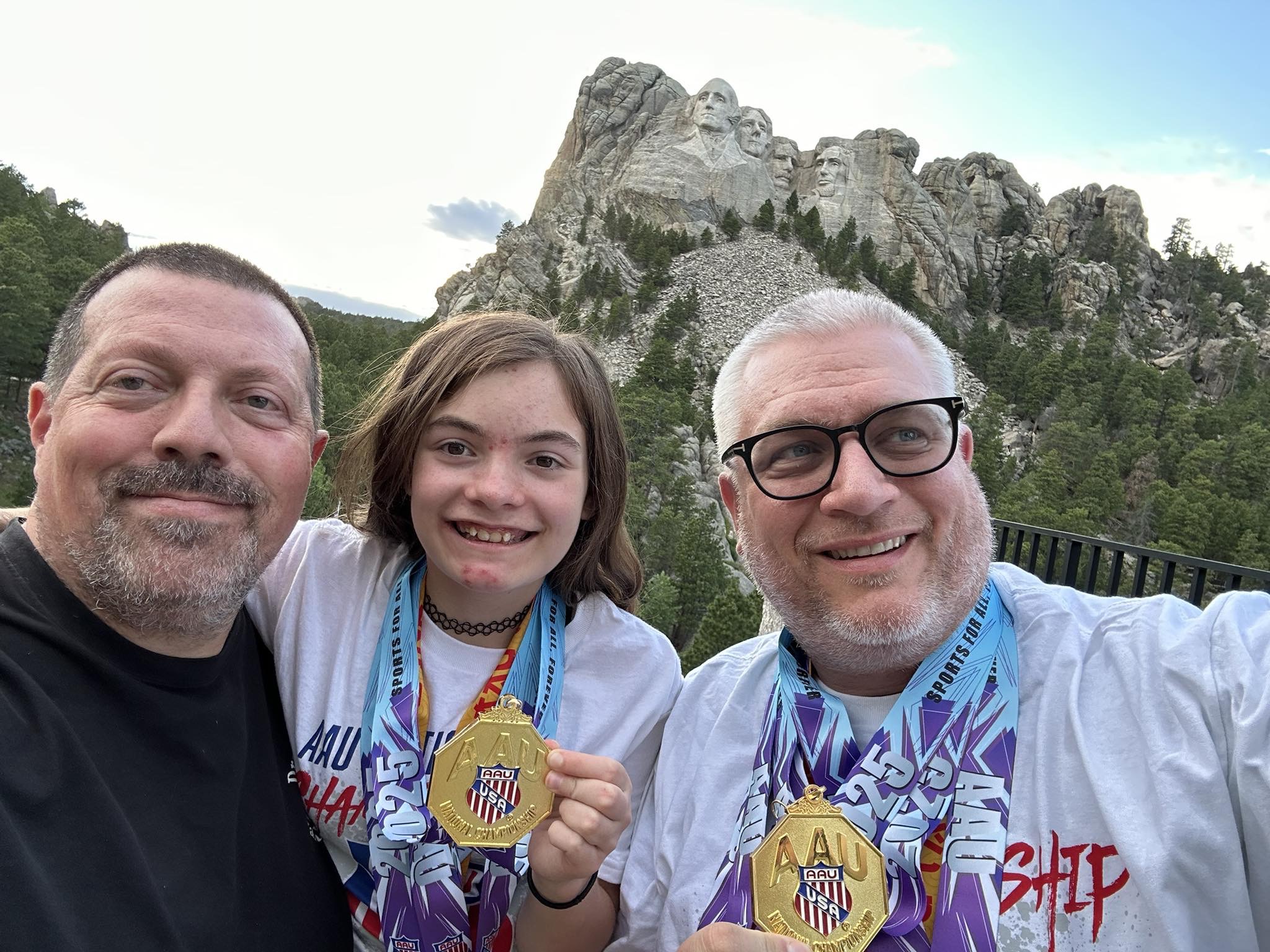 Dragon Spirit team members with medals near Mount Rushmore